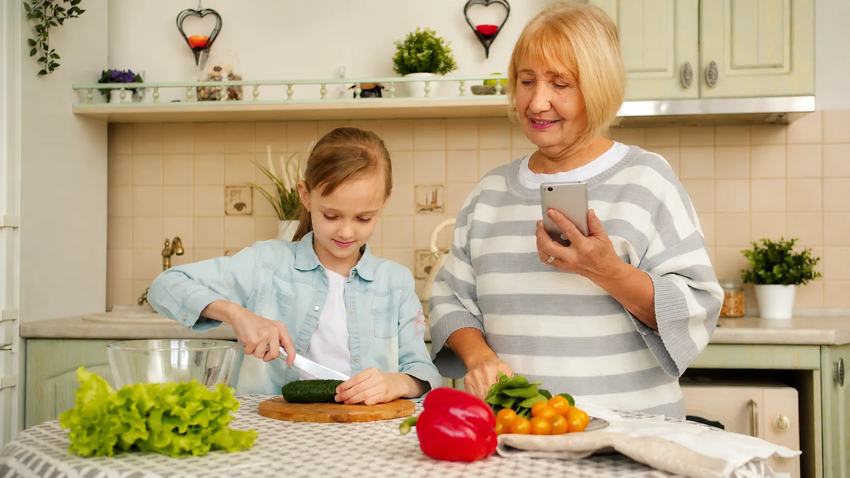 Une grand-mère et une enfant préparent un repas ensemble dans une cuisine familiale.